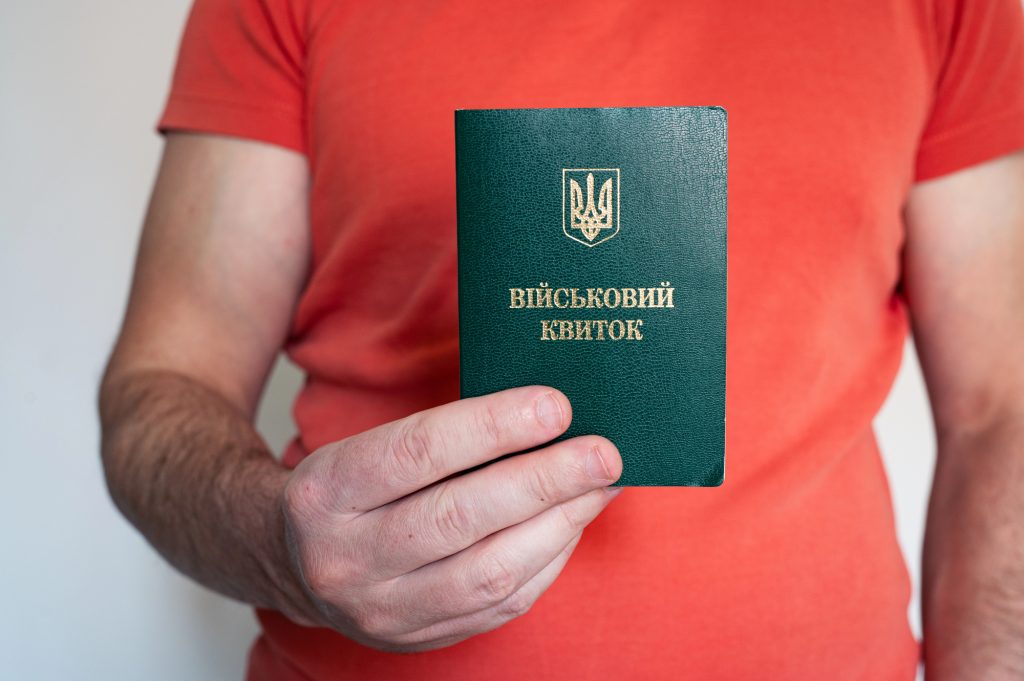 чоловік тримає військовий квиток