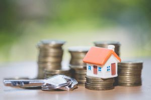 фігурка будинку та ключі стоять на копійках
