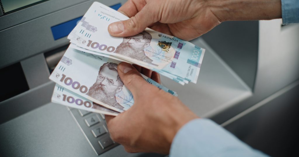 Гривня, банкомат, готівка, руки